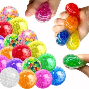 May include: A collection of round, translucent stress balls filled with small, colorful water beads. The spheres appear in various vibrant colors including red, orange, yellow, green, blue, purple, pink, and clear, showing a textured interior.
