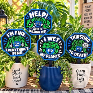 May include: Four octagonal plant markers with black, blue, and white graphics. The signs feature cartoon potted plants with faces and text: HELP! SHE'S KILLING ME!, I'M FINE. EVERYTHING'S FINE., I WET MY PLANTS, and THIRSTING TO DEATH! SEND HELP.