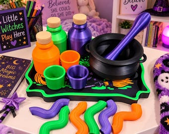 May include: A set of colorful potion-making accessories including a black cauldron with a purple stirring rod, orange and green bottles with wooden stoppers, matching cups, and wavy plastic shapes arranged on a black tray with green trim.