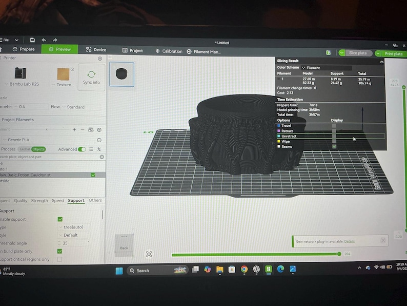 Pode incluir: Uma tela de computador exibindo a interface do software Bambu Studio com um modelo 3D de um caldeir&atilde;o preto em uma placa de constru&ccedil;&atilde;o digital. O software mostra resultados de fatiamento, uso de filamento e tempo estimado de 3h 57m.