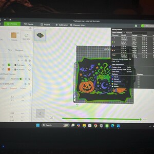 Pode incluir: Um ecr&atilde; de computador a exibir o software de corte Bambu Lab P2S com uma pr&eacute;-visualiza&ccedil;&atilde;o digital de um tabuleiro retangular com tema de Halloween. O design apresenta um caldeir&atilde;o preto, uma ab&oacute;bora laranja, um morcego e uma vassoura.