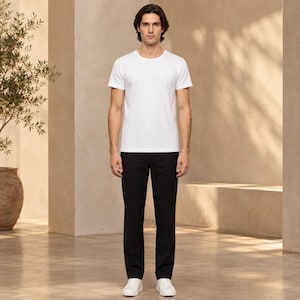 May include: A plain white short-sleeved crew neck t-shirt paired with solid black trousers and white sneakers. The t-shirt features a simple, clean design with a round neckline and short sleeves, while the trousers have a straight-leg cut.