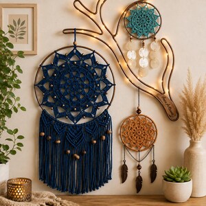 May include: A wall-mounted display featuring three circular dreamcatchers with intricate crochet patterns in dark blue, teal, and orange. The dark blue piece has long fringe and wooden beads, while the others feature hanging shell discs and metal feathers.