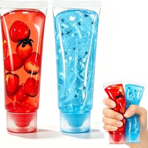 May include: Two large clear squeeze tubes filled with gel, one containing red strawberry-shaped charms and the other blue star-shaped glitter. A hand holds two smaller versions of these tubes, one red with strawberries and one blue with stars.