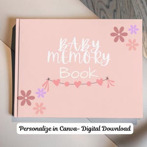 May include: A light pink rectangular book with the white text BABY MEMORY BOOK centred on the cover. The design features a string of pink hearts and small pink and purple flowers in the corners. A white label reads Personalize in Canva- Digital Download.