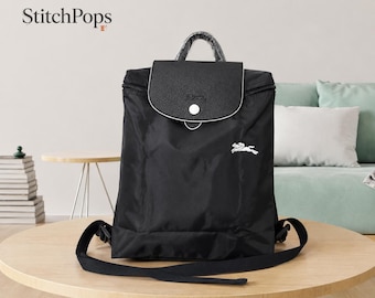 Mochila Longchamp Le Pliage negra de nailon plegable, ideal para viajes y como mochila de lujo ligera para mujer.