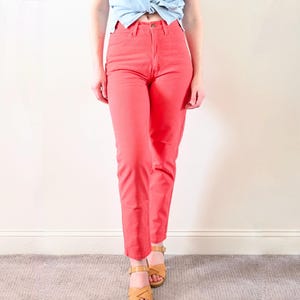 Può includere: Pantaloni color corallo dalla vestibilità classica. I pantaloni hanno vita alta e gamba dritta. La modella indossa i pantaloni con un top azzurro e sandali color cuoio. I pantaloni sono realizzati in materiale robusto.