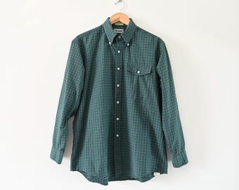 Puede incluir: Una camisa de manga larga a cuadros verdes y blancos con un bolsillo en el pecho.