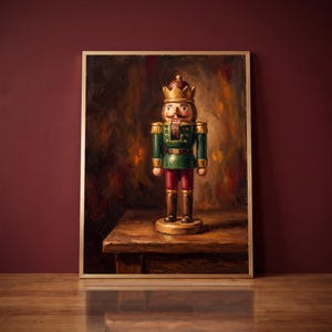 May include: An oil painting in a gold frame depicting a nutcracker figure wearing a gold crown, a green jacket with gold epaulets, and red trousers. The nutcracker stands on a wooden surface against a dark, textured, and moody background.