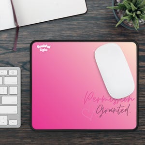 May include: A rectangular mouse pad with a pink to light orange gradient background. The text Bashful Byte appears in the top left corner. The text Permission Granted is written in a cursive font in the bottom right, accompanied by a heart outline.