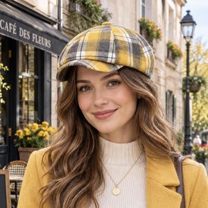 May include: A yellow, gray, and white plaid newsboy cap with a structured brim, paired with a cream-colored ribbed mock-neck sweater, a mustard yellow coat, blue denim jeans, a gold pendant necklace, and a brown leather shoulder bag.