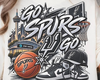 May include: A cream-colored sweatshirt featuring a graphic print with the text GO SPURS GO, the San Antonio skyline, the AT&T Center, a basketball hoop, a basketball with the Spurs logo, a black baseball cap, and high-top sneakers.