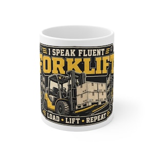 May include: A white ceramic mug featuring a graphic of a yellow forklift carrying stacked boxes. The text reads I SPEAK FLUENT FORKLIFT and LOAD LIFT REPEAT in bold yellow and white lettering against a dark background with industrial warehouse elements.