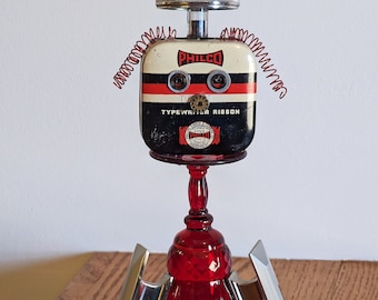 Athena, Warrior Robot - Mixed Media Sculpture, Re-Purposed Wonderful Figure of Red Glass, Typewriter & Baking Tin, Drawer Pulls, TV Dial