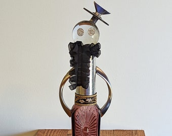 Noel - Mixed Media Sculpture, Re-Purposed Elegant Woman of TV Dial, Glass Ball, Buttons, Ribbons, Drawer Pulls, Glass Bottle, Baking Tin