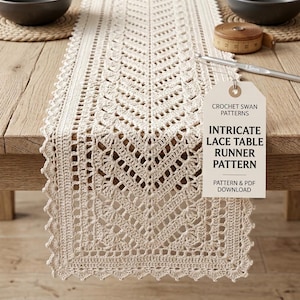 May include: A cream-colored crochet table runner with a chevron pattern and scalloped edges. A white tag attached with string displays the text: CROCHET SWAN PATTERNS INTRICATE LACE TABLE RUNNER PATTERN PATTERN & PDF DOWNLOAD. A 3.5mm crochet hook is visible.
