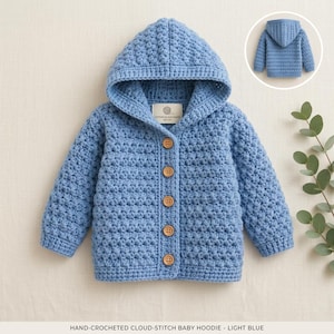 May include: A light blue hand-crocheted hoodie featuring a textured cloud-stitch pattern, a hood, and five round wooden buttons down the front. A small white rectangular label is sewn inside the neckline. A smaller view of the back is shown.