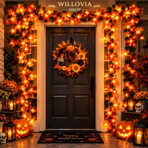 May include: A black front door decorated for Halloween with a lighted maple leaf garland, a wreath featuring a jack-o'-lantern, sunflowers, and pinecones, two jack-o'-lanterns, two lanterns, two skulls, and a mat with the text Happy Halloween.