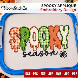 Könnte beinhalten: Ein Stickdesign in einem blauen Rahmen mit dem Wort SPOOKY in einer tropfenden Schriftart mit orangefarbenen Karos, grünen Karos, cremefarbenen und grünen Punkten. Darunter ist das Wort season in Schwarz mit einer kleinen schwarzen Spinne gestickt.