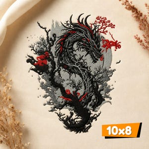 Puede incluir: Un diseño bordado sobre tela color crema que presenta un dragón negro con detalles en rojo, rodeado de ramas de árboles oscuras y un fondo circular gris. El diseño incluye una pequeña etiqueta naranja en la esquina con el texto 10x8 cm.