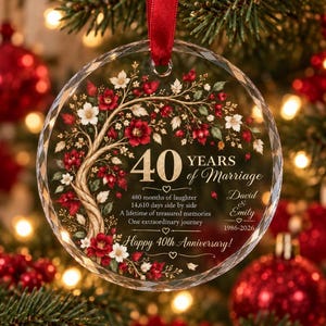 May include: A round, faceted glass ornament with a red ribbon, featuring a tree illustration with red and white flowers. Text reads: 40 YEARS of Marriage, 480 months of laughter, 14,610 days side by side, A lifetime of treasured memories, David & Emily, 1986-2026, Happy 40th Anniversary!