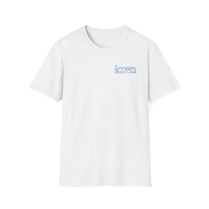 May include: A white short-sleeved t-shirt featuring a crew neckline. On the upper left chest area, the text "Livingston Skate Club" is printed in a blue, cursive script font. The garment is plain white with no other visible patterns or designs.