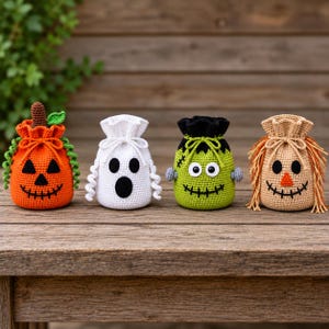 May include: Four small, crocheted drawstring pouches featuring Halloween-themed designs: an orange pumpkin with green vines, a white ghost, a lime green monster with bolts, and a tan scarecrow with fringe hair, all with black stitched facial details.