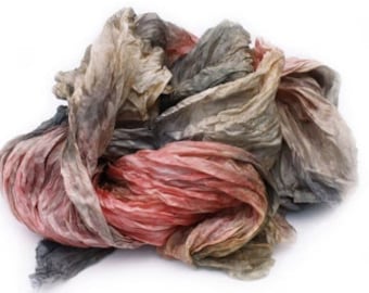 May include: A bundle of soft, crinkled fabric in shades of gray, brown, and pink. The fabric is loosely tied together and appears to be made of silk or a similar material.