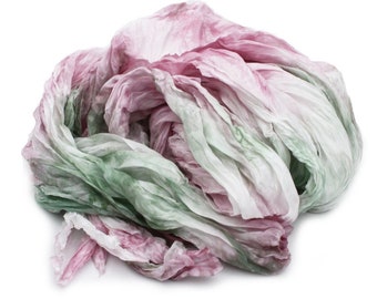 May include: A soft, crinkled fabric scarf in shades of pink and green. The fabric is gathered and twisted, creating a textured and organic look.
