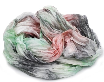 May include: A soft, crumpled scarf in shades of green, pink, and gray. The scarf is made of a lightweight fabric and has a flowing, drapey texture.