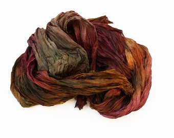 May include: A crumpled piece of fabric in shades of brown, red, and green. The fabric is soft and flowing, with a slightly textured surface.