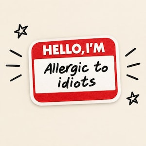 May include: A rectangular name tag sticker with a red border and white center. The text HELLO, I'M is printed in white at the top, and the black handwritten text Allergic to idiots is centered below. Two black stars and short lines accent the corners.