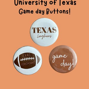 May include: Three circular pin-back buttons featuring University of Texas Longhorns themes. One white button reads TEXAS Longhorns in brown. Another white button shows a brown football with TEXAS Longhorns text. A brown button reads game day!