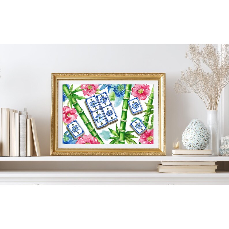 May include: A framed watercolor print featuring a gold frame. The artwork depicts bamboo stalks, pink flowers, blue flowers, and blue and white tiles. The print is displayed on a white shelf with books and decorative items.