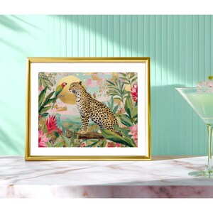 May include: A framed art print featuring a leopard and a parrot in a jungle setting. The artwork has a gold frame and depicts a leopard with a spotted coat, a parrot, and tropical foliage in shades of green, pink, and gold.