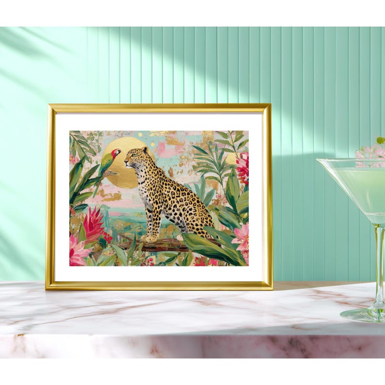 May include: A framed art print featuring a leopard and a parrot in a jungle setting. The artwork has a gold frame and depicts a leopard with a spotted coat, a parrot, and tropical foliage in shades of green, pink, and gold.