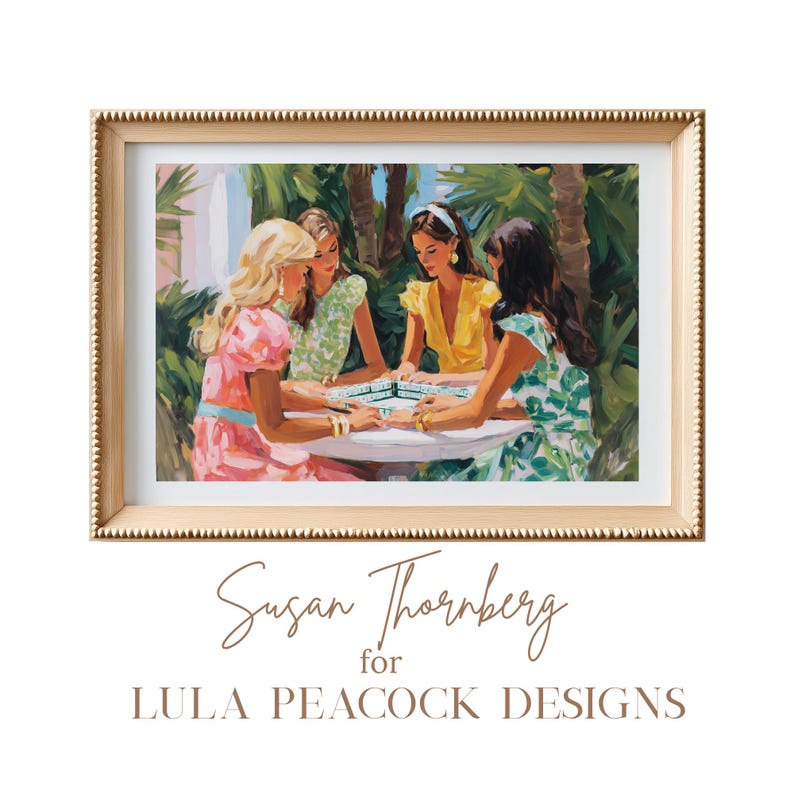 May include: A framed art print featuring a painting of four women playing a game outdoors. The women are dressed in colorful dresses, and the artwork is set in a gold frame. The artist's name and design studio are displayed below the artwork.