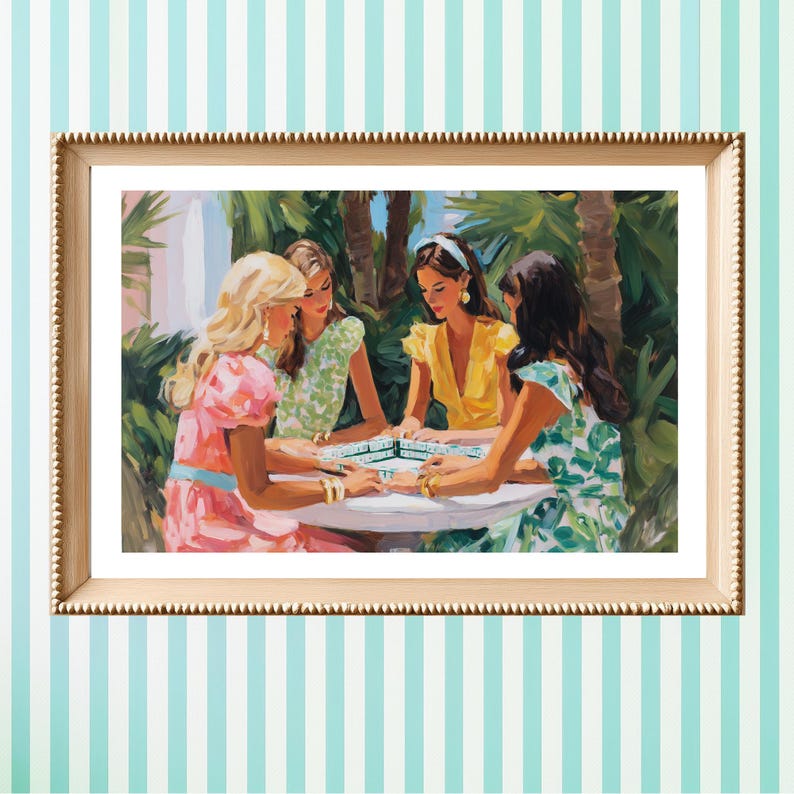 May include: A framed painting depicts four women gathered around a table, playing a game. The women are dressed in colorful dresses, with a tropical background. The frame is gold, and the background is a light blue and white striped pattern.