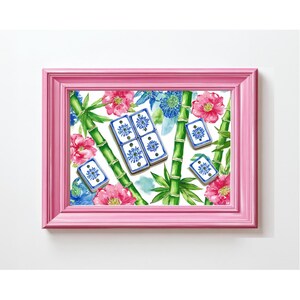 May include: A pink framed print featuring a floral and bamboo design. The artwork includes pink and blue flowers, green bamboo stalks, and blue and white dominoes. The background is white.