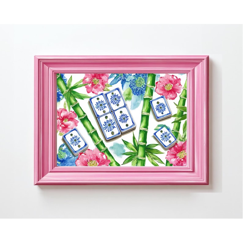 May include: A pink framed print featuring a floral and bamboo design. The artwork includes pink and blue flowers, green bamboo stalks, and blue and white dominoes. The background is white.