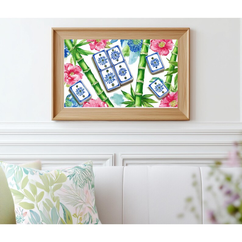 May include: A framed print featuring a watercolor design of bamboo stalks, pink flowers, blue floral accents, and blue and white tiles. The artwork is set against a white background and framed in a light wood frame. The print is mounted on a white wall.
