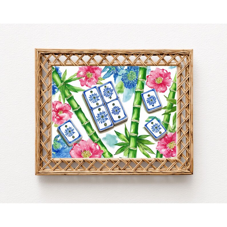 May include: A framed print featuring a watercolor design with bamboo stalks, pink and blue flowers, and blue and white tiles. The frame is made of woven light brown material.