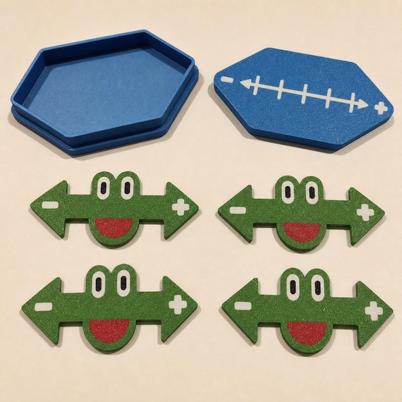 Complete set of four green frog math markers with the open blue storage tray and decorated blue lid on a cream background.