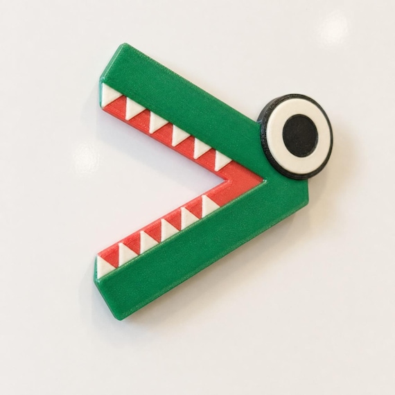 Green greater-than ChompCompare crocodile with coral-red mouth, white teeth, and one large eye on a blank whiteboard.