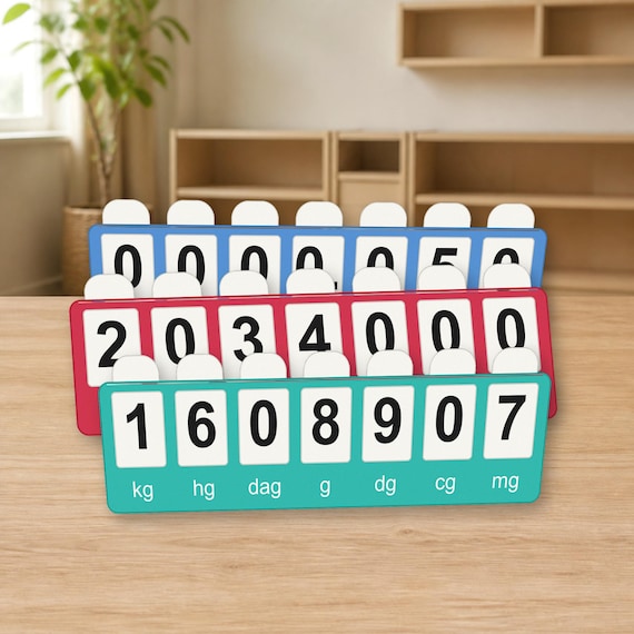 Three red, blue, and teal MeasureMap metric boards arranged closely on a light wood classroom table, with white number tabs and black numerals.