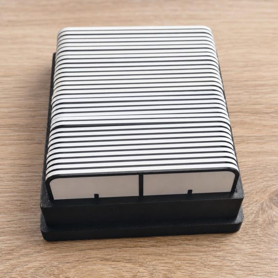 Full EqualLink tile set stacked neatly inside the black organizer tray in a close elevated view on a wood table.