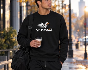 May include: A black crewneck sweatshirt featuring a white and orange graphic logo with the text VYND on the chest. The sweatshirt has long sleeves and a ribbed neckline, cuffs, and hem, paired with matching black sweatpants.