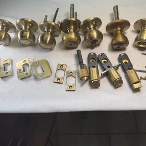 Kwikset Antique Brass Door knobs lot with  Latchplates Deadlatch with matching nails.