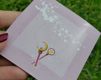 May include: A pink square sticker with a white floral design and two cartoon wands. The wands are gold and pink with a crescent moon and a star on top. The text "Pink Princess" is at the bottom of the sticker.