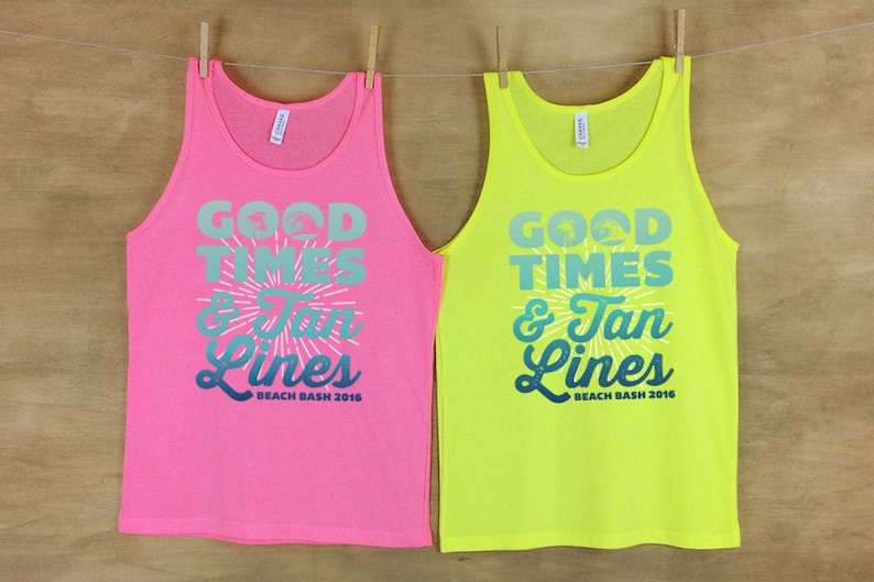 May include: Two tank tops with the text "Good Times & Tan Lines Beach Bash 2016". One tank top is pink and the other is yellow.